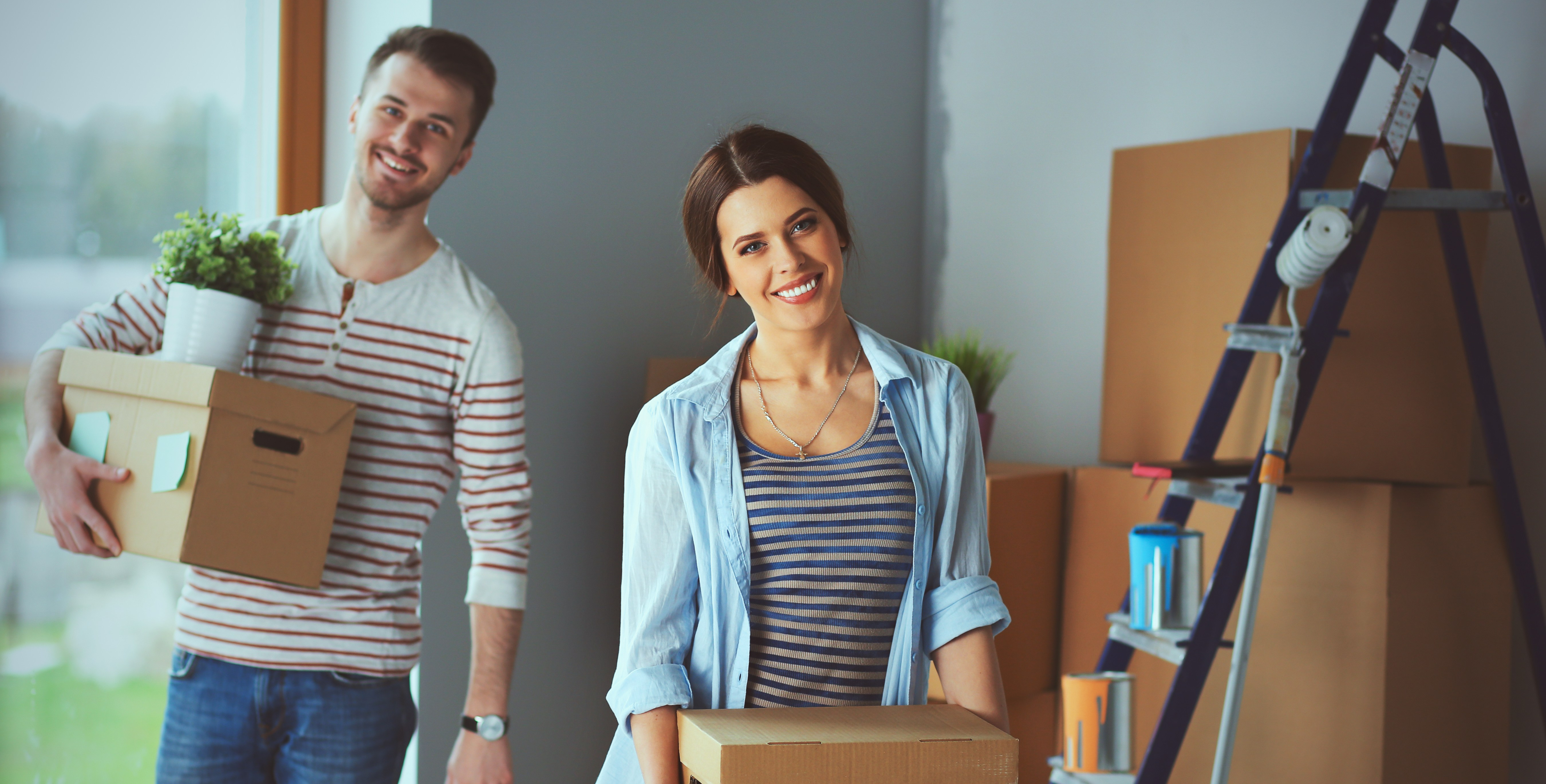 Happy young couple unpacking or packing boxes and moving into a new home